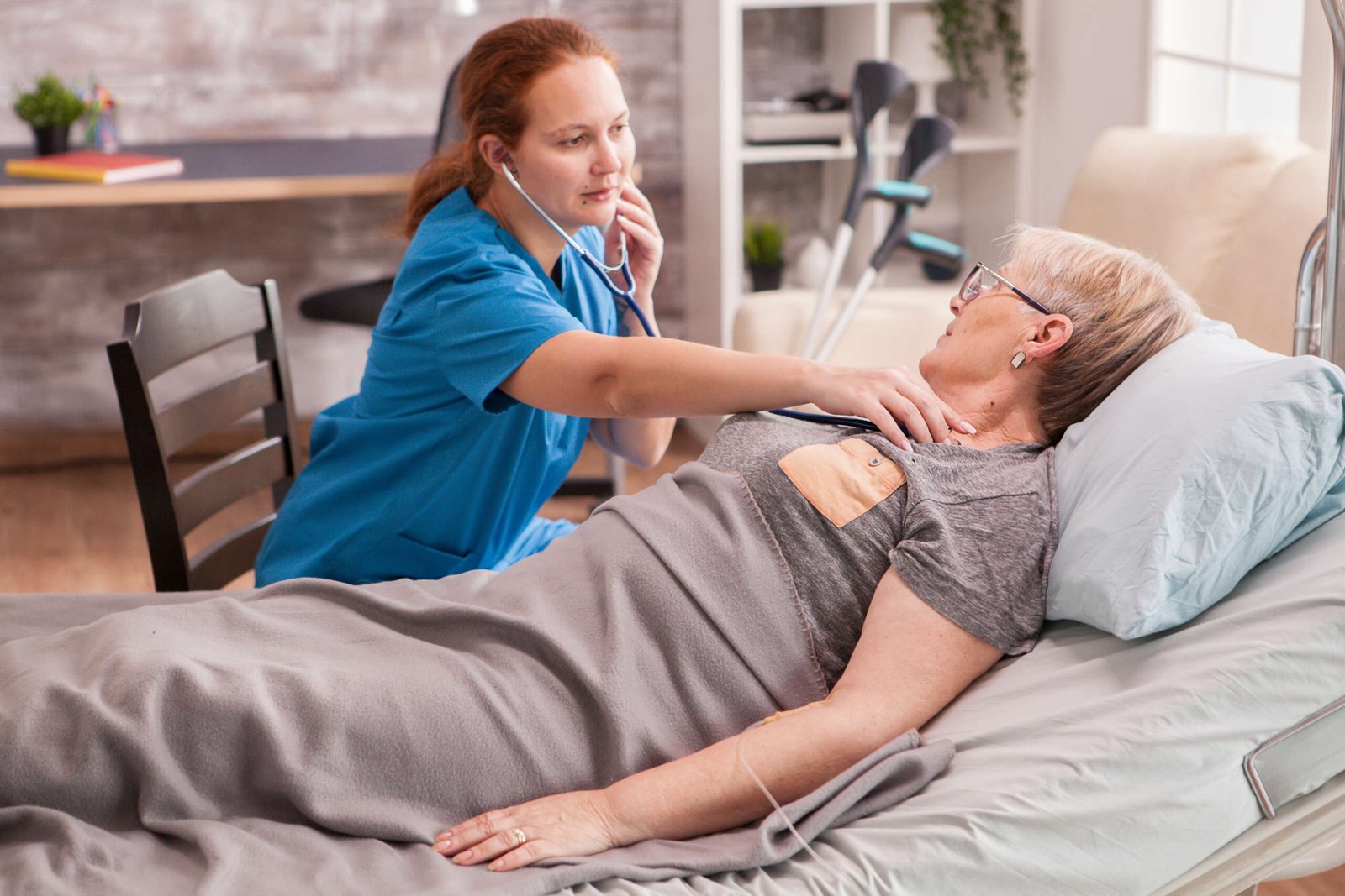 female doctor using stethoscope check old woman heart nursing home scaled